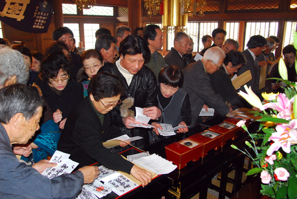 檀家の皆様が新年のお札をお受けになります。